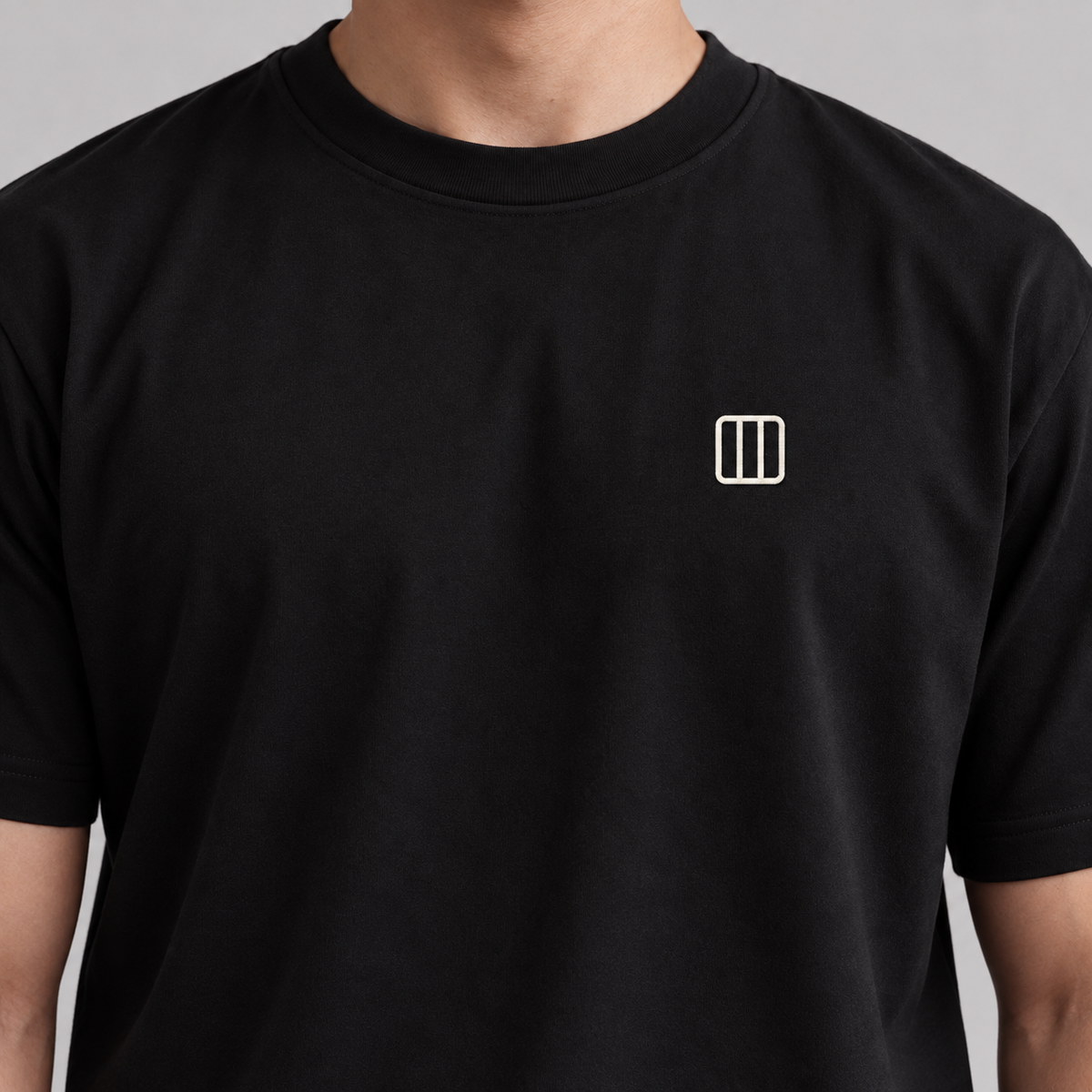 Architect Column Tee in black with white embroidered column icon